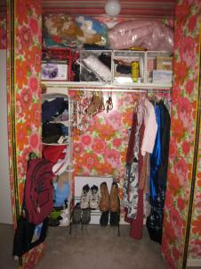 organized and clean closet with shoes on a shoe rack, blankets on top shelf above the crates, extra hangers in the center available for guests