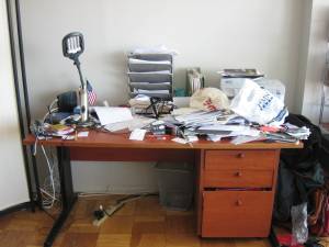 image of paper and miscellaneous covering the desk and hiding a printer